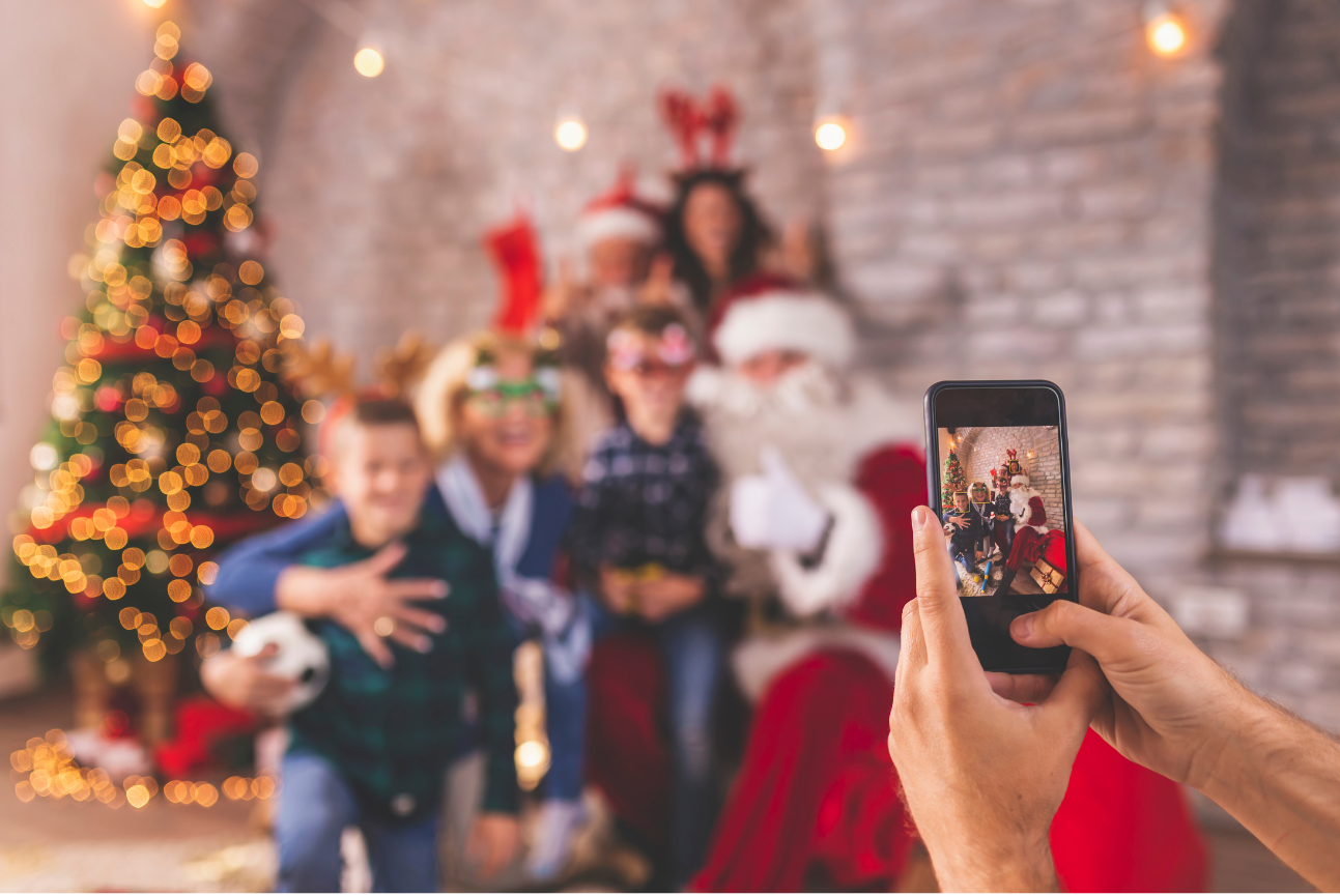 parent with cell phone taking kids picture with santa claus